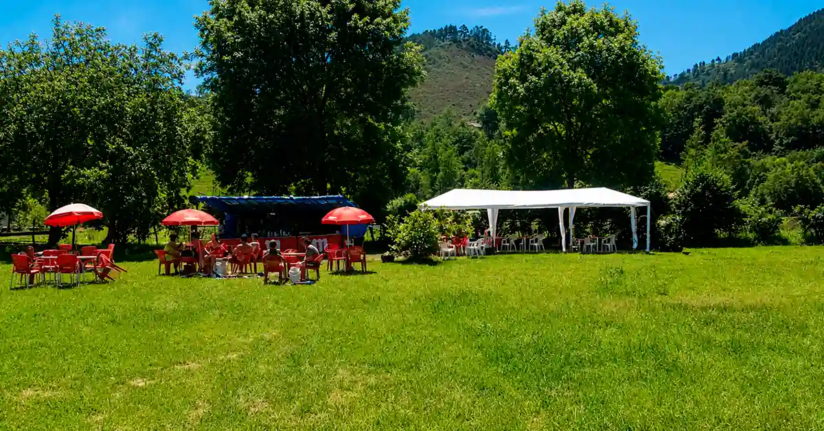 Uno de los bares y chiringuitos del descenso del Sella con sus mesas, sombrillas, carpa y barra