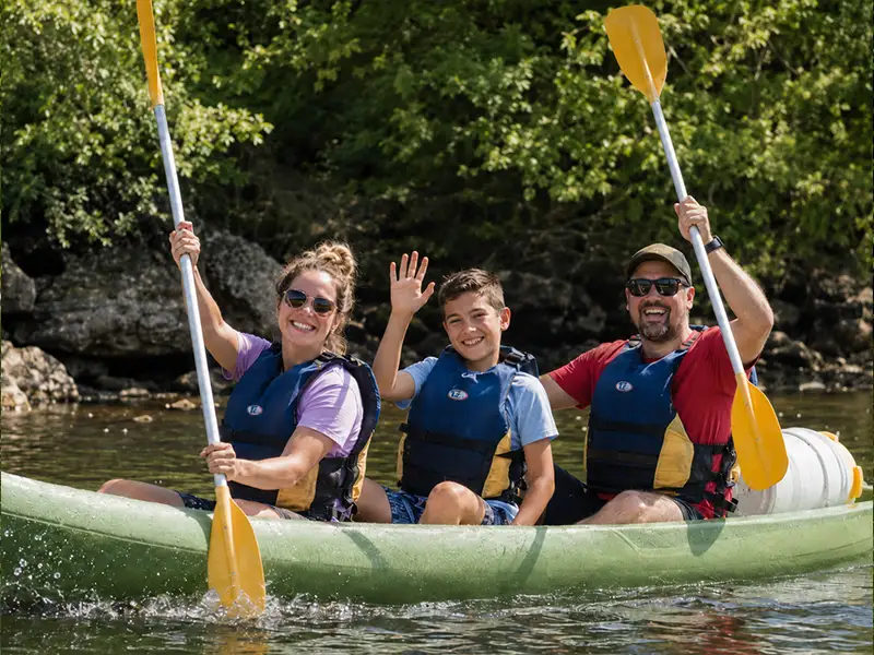 Familia haciendo el descenso del Sella en canoa con una embarcación de tipo K3 de la empresa Canoas El Moyau