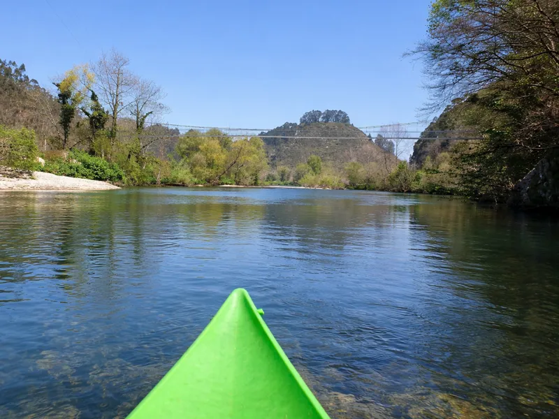 Una canoa pasa por debajo de la Pasarela de Cuevas.