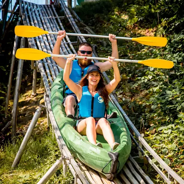 Pareja divirtiéndose bajando por la rampa en la baja del sella en canoa con El Moyau - Consulta nuestras tarifas y precios 2026 en Arriondas.